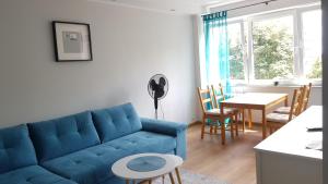 a living room with a blue couch and a table at Apartament TURKUSOWY in Kalisz
