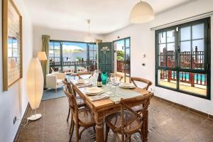 Un comedor con mesa y sillas de madera. en Lanzahost Villa Mimosa, en Punta Mujeres