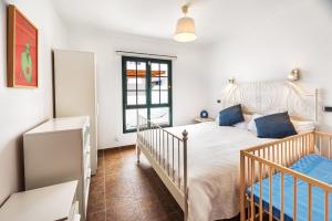 Lanzahost Villa Mimosa في بونتا موخيريس: غرفة نوم بسرير وسرير أطفال