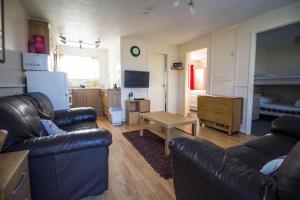 a living room with two leather couches and a table at Lovely 5 Berth Chalet In Hemsby Nearby Great Yarmouth Ref 73034c in Hemsby