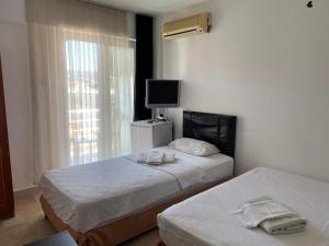 a hotel room with two beds and a television at Blue otel çeşme in Cesme