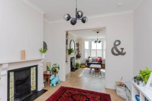 a living room with white walls and a fireplace at Modern 3 Bedroom Home in Honor Oak beside Nature Reserve in London