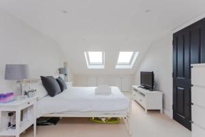 a bedroom with a bed with a desk and a tv at Modern 3 Bedroom Home in Honor Oak beside Nature Reserve in London