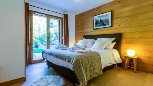 a bedroom with a bed with a wooden wall at Appartement Green in Chamonix