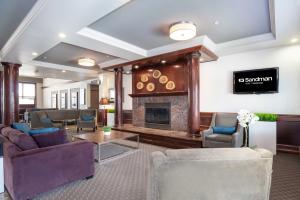 a lobby with couches and a fireplace in a building at Sandman Hotel Saskatoon in Saskatoon