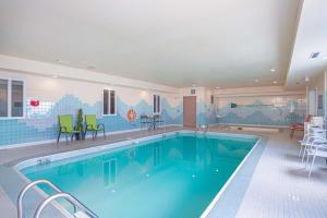 a large swimming pool with chairs and a table at Sandman Hotel Saskatoon in Saskatoon