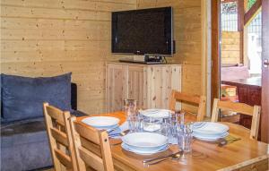 a wooden table with plates and a television in a cabin at Nice Home In Sianozety With Kitchenette in Sianozety