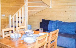 a dining room with a table and a blue couch at Nice Home In Sianozety With Kitchenette in Sianozety