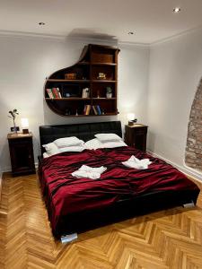 sypialnia z dużym łóżkiem i czerwonym kocem w obiekcie Varga Apartman w mieście Sopron