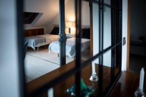 Habitación con vistas a un dormitorio con cama y espejo. en Fabulos Ático con vistas al Monasterio, en San Lorenzo de El Escorial