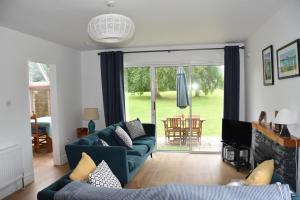a living room with blue couches and a sliding glass door at Idyllic 3-Bed House minutes from village & beach in Rathmullan