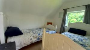 a bedroom with two beds and a window at Idyllic 3-Bed House minutes from village & beach in Rathmullan