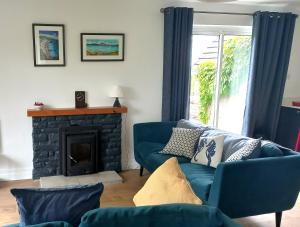 a living room with a blue couch and a fireplace at Cottage on the grounds of Rathmullan House Hotel in Rathmullan