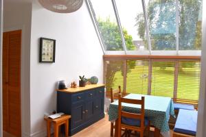 a dining room with a table and some windows at Idyllic 3-Bed House minutes from village & beach in Rathmullan