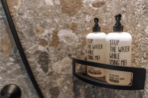 two bottles of soap sitting on a shelf in a bathroom at The Poolhouse Boutique Lodge in Saalbach Hinterglemm