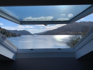 uma vista para um lago a partir de um quarto com uma janela em The Shore House em Lochgoilhead