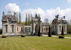 an old house with a large yard in front of it at Superbe Appartement Circuit des 3 Chateaux in Folembray