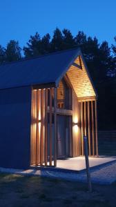 une petite maison en bois avec un poteau en face de celle-ci dans l'établissement Stark House Gallery, à Borsk