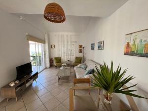 a living room with a couch and a tv at The Best prime location lovely 1 bedroom apartment in Paphos City
