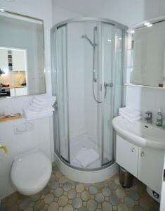y baño con ducha, aseo y lavamanos. en Penthouse MEERblick, App 66, en Westerland