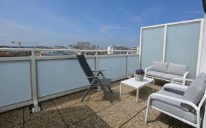 un balcón con sillas y una mesa en el techo en Penthouse MEERblick, App 66, en Westerland