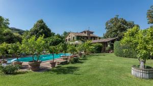 un jardín con piscina y una casa en VILLA DUE VIGNE 8, Emma Villas, en Monte Castello di Vibio