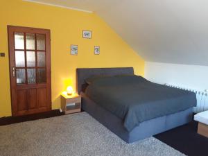 um quarto com uma cama e uma parede amarela em Čavoj Guest House em Čavoj