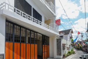 un bâtiment avec des portes orange dans une rue dans l'établissement RedDoorz Plus near Pasar Gede Solo, à Solo