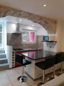 a kitchen with a counter and some chairs in it at Appartement paisible entre terre et mer in Cabrières