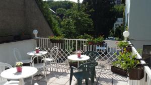 2 tafels en stoelen op een balkon met planten bij Pension Kern in Praag