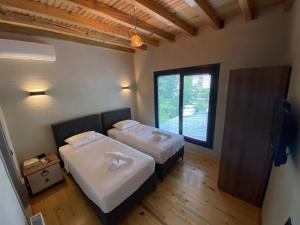 薩潘賈的住宿－ZK Wooden Village，带窗户的客房内的两张床