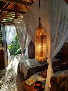 a room with white curtains and a chandelier at Casa Embira - 300 metros da Praia do Lago Verde in Alter do Chao
