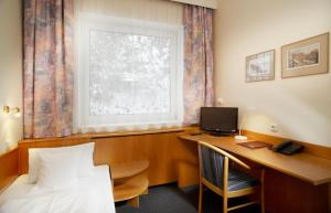 een kamer met een bureau, een computer en een raam bij Pension Kern in Praag
