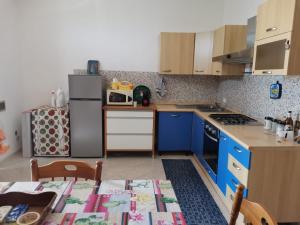 a kitchen with a refrigerator and a table with a tablecloth at Casa Vacanze - Da Peppina in Petrosino