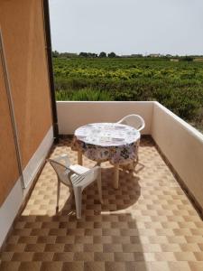 patio con mesa y 2 sillas en el balcón en Casa Vacanze - Da Peppina, en Petrosino