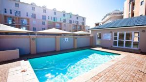a large swimming pool in front of a building at Muizenberg Mountain View Apartment in Cape Town