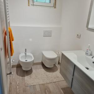 La salle de bains blanche est pourvue de toilettes et d'un lavabo. dans l'établissement Civico 25, Carcioni - Belgirate, à Belgirate