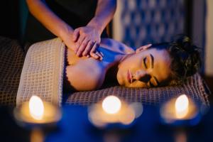 a woman laying on a couch next to candles at Burrendale Hotel Country Club & Spa in Newcastle