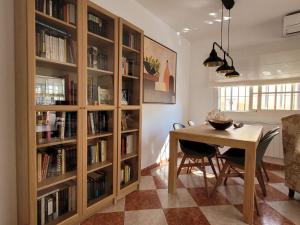 a dining room with a table and book shelves at Chalet con piscina a 300 m del mar in Chiclana de la Frontera