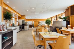 ein Restaurant mit Tischen und Stühlen und eine Küche in der Unterkunft myNext - Hotel Rudy in Wien
