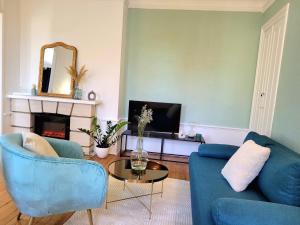 - un salon avec deux chaises bleues et une cheminée dans l'établissement LA PARENTHÈSE HAVRAISE - Parking privé Plein centre & Très calme, au Havre