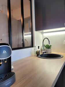 a kitchen counter with a coffee maker and a sink at LA PARENTHÈSE HAVRAISE - Parking privé Plein centre & Très calme in Le Havre