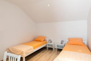Habitación con 2 camas, paredes blancas y suelo de madera. en Apartments Katarina, en Dubrovnik