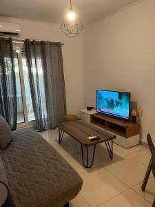 a living room with a tv and a coffee table at ALKYONI in Athens