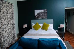 a bedroom with a large bed with yellow pillows at Montclair Hotel and Casino in Nyanga