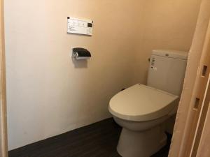 a bathroom with a toilet and a paper on the wall at みのる庵 