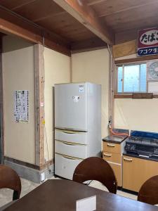 a kitchen with a refrigerator and a table at みのる庵 