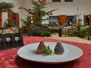 Due alberi di Natale in miniatura su un piatto su un tavolo di Pension a restaurace U sousedů a Strážný