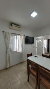 a living room with a table and a tv and a window at Departamento Don Nico in San José de la Dormida