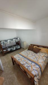 a bedroom with a bed and a bench in it at Departamento Don Nico in San José de la Dormida